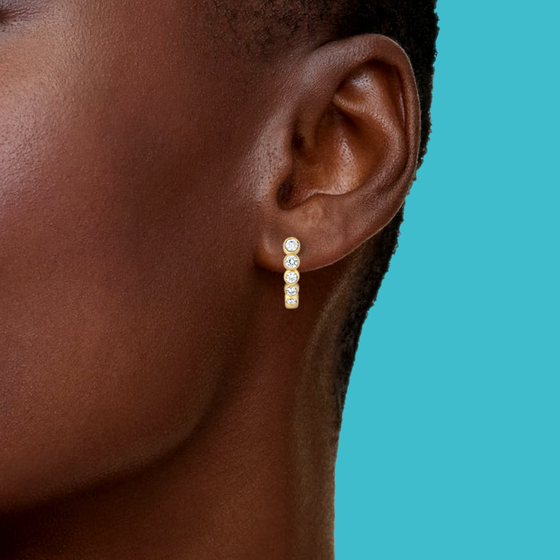 Petite Frites Evening Out earrings in yellow gold with diamonds shown on a close up image on model
