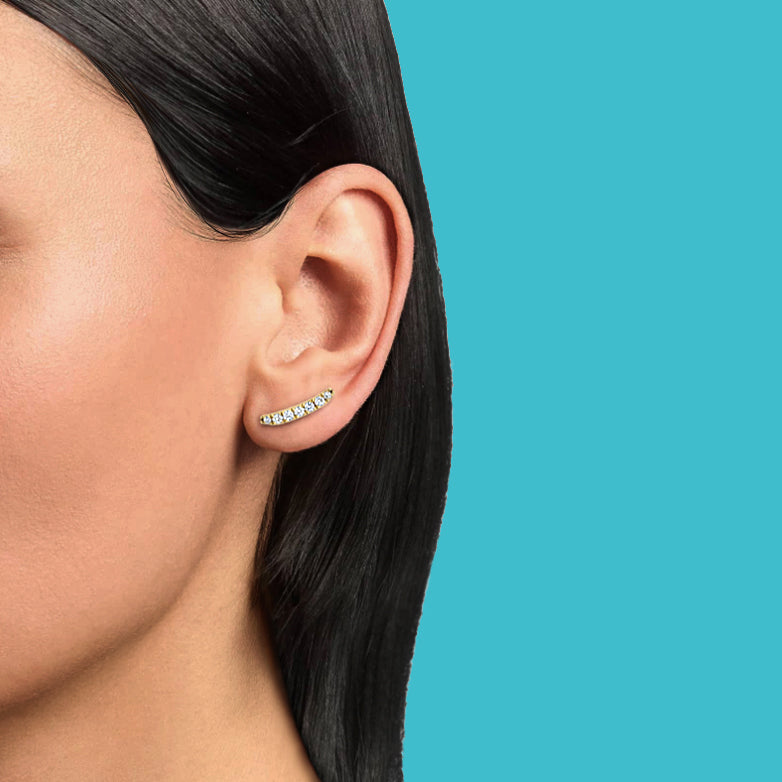 Petite Frites Frites earrings in yellow gold with diamonds shown on a close up image of model worn horizontally