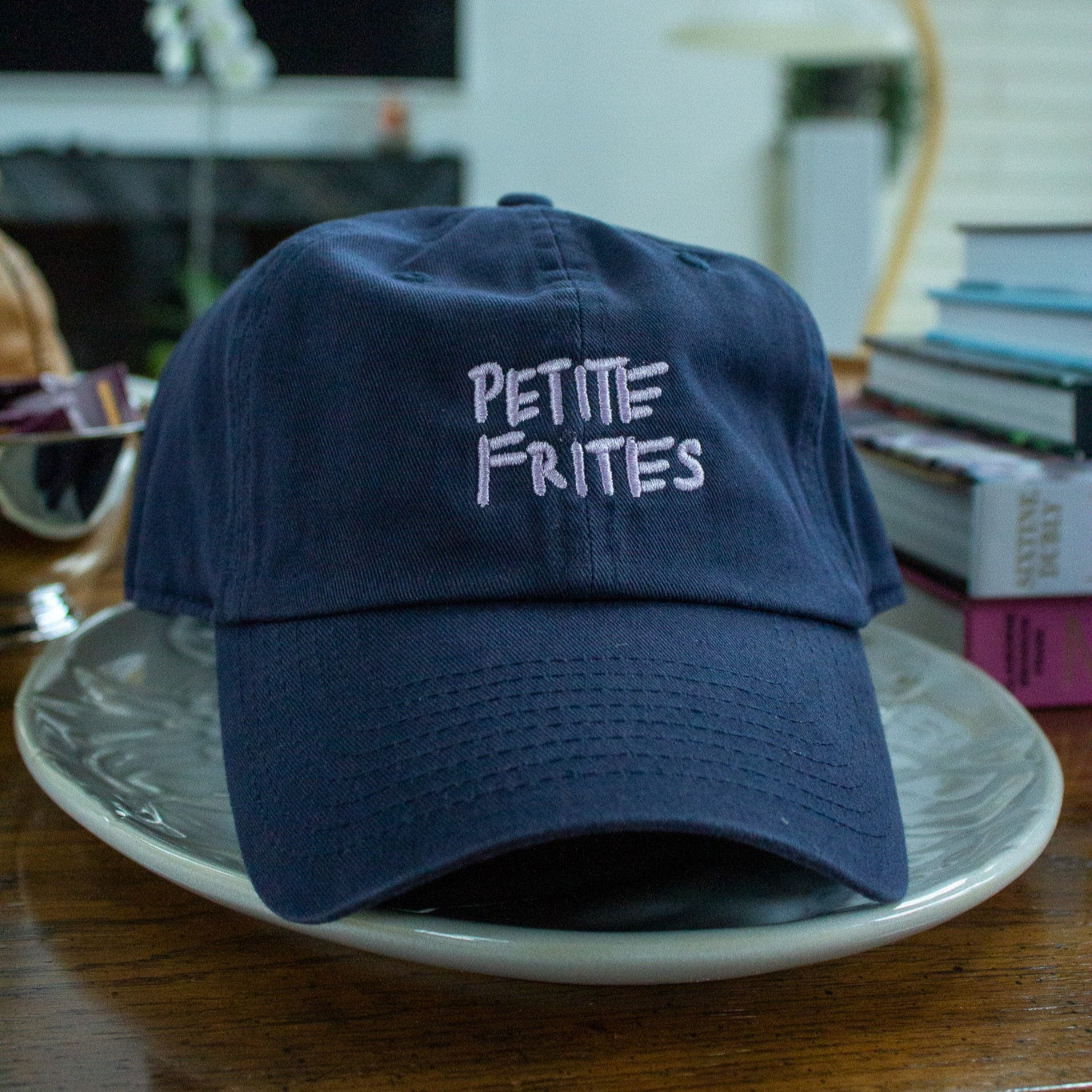 This is the Petite Frites dad cap in navy with lavender embroidery